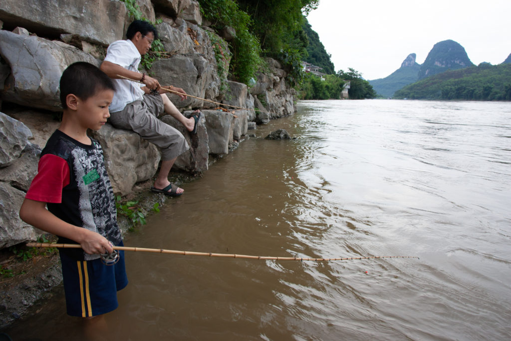 Picture of dad and son fishing with bamboo poles