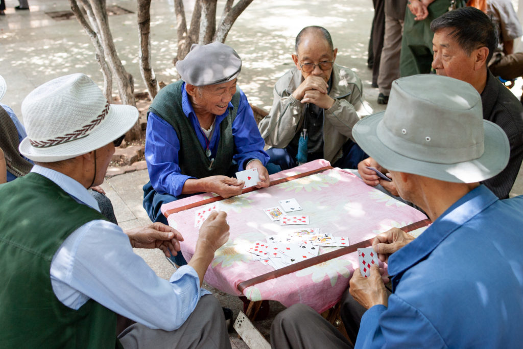 Men playing cards in park