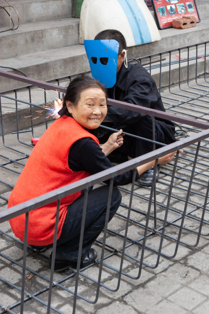 Man welding while woman helps