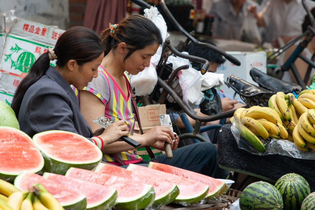 Two women peeling water chestnuts