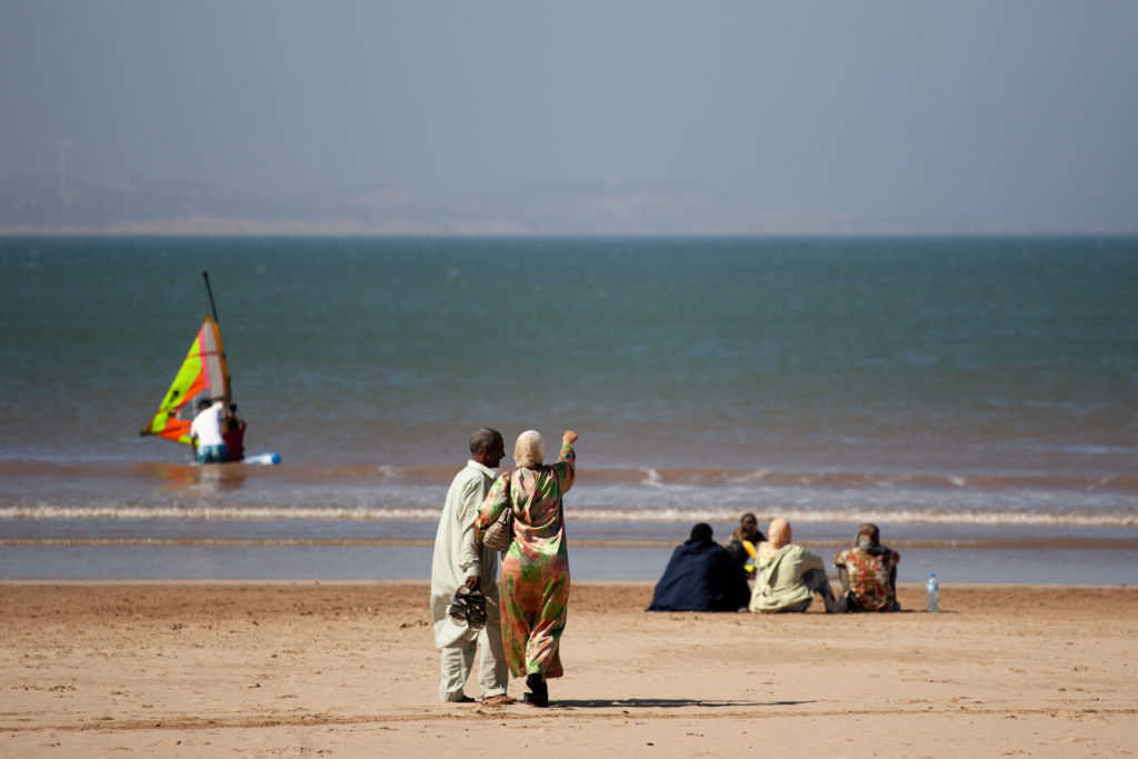 People on a beach, with woman pointing