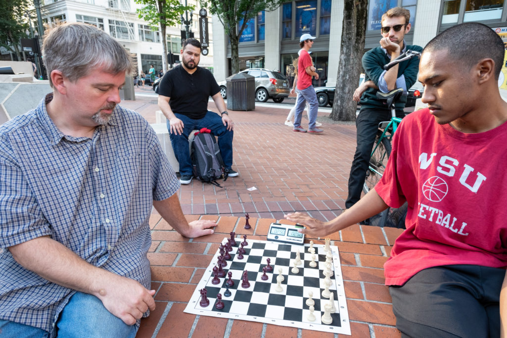 Two people playing chess outside