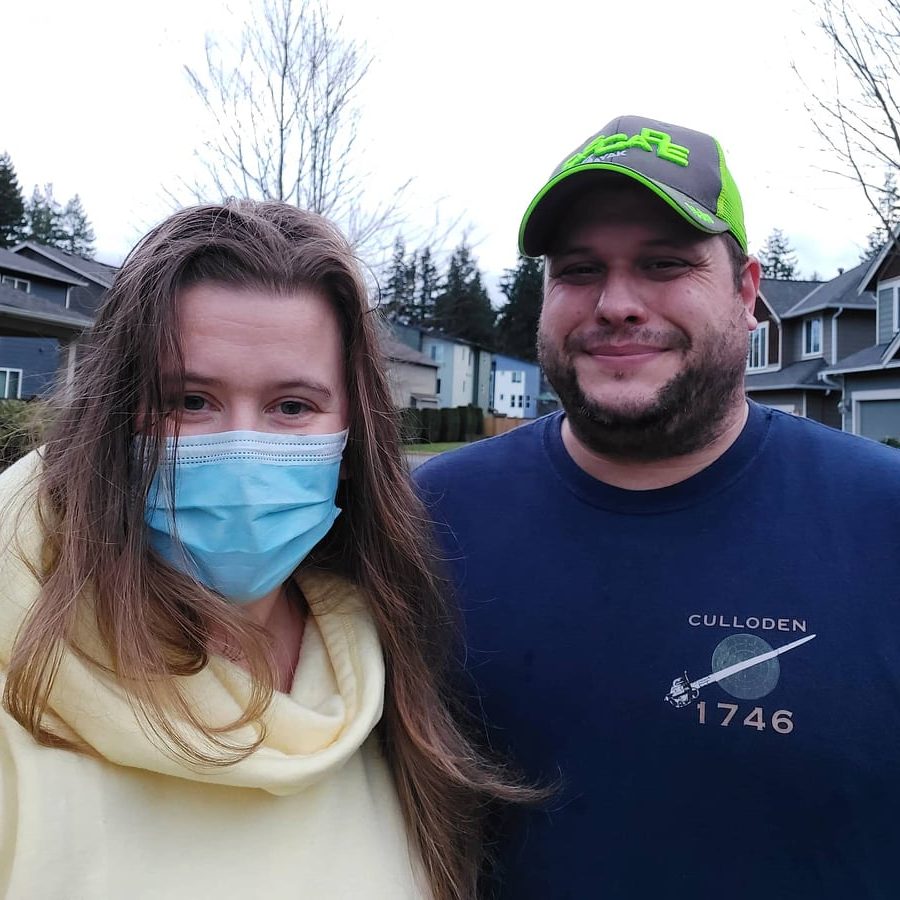 Two people, one wearing a surgical mask