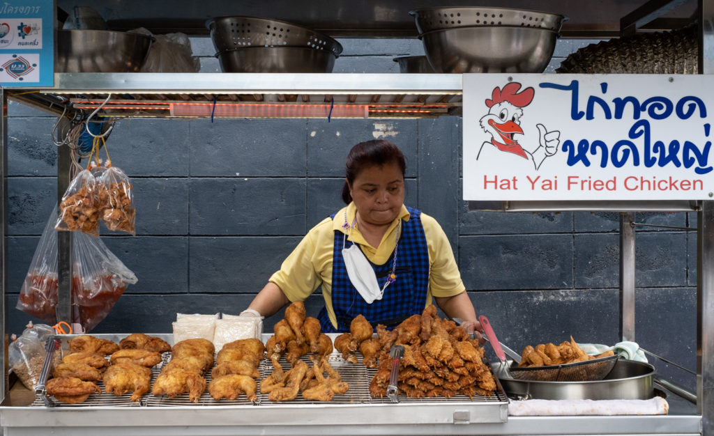 Woman selling fried chicken from a cart