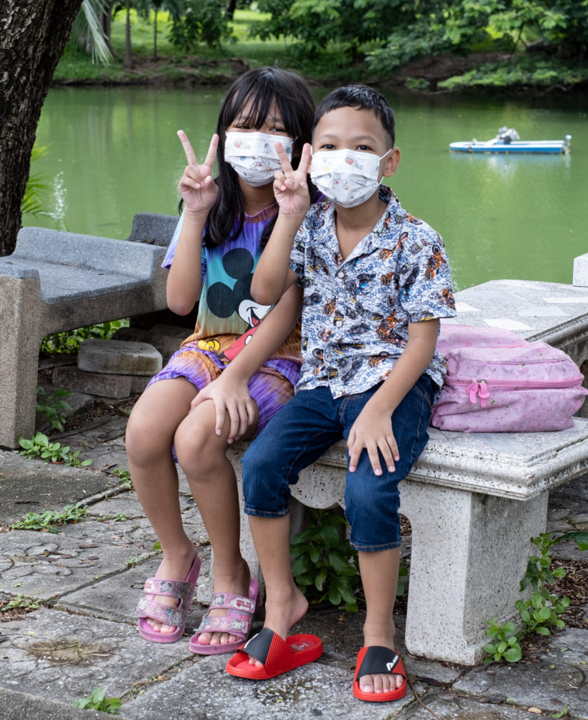 Two kids flashing the peace sign