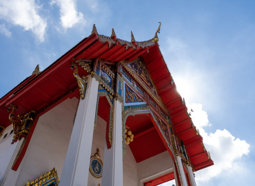 Red and white temple against blue sky