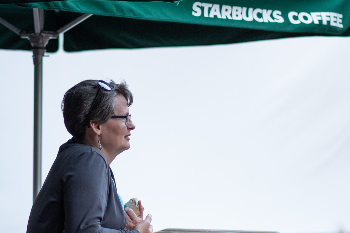 Woman sitting under Starbucks Umbrella