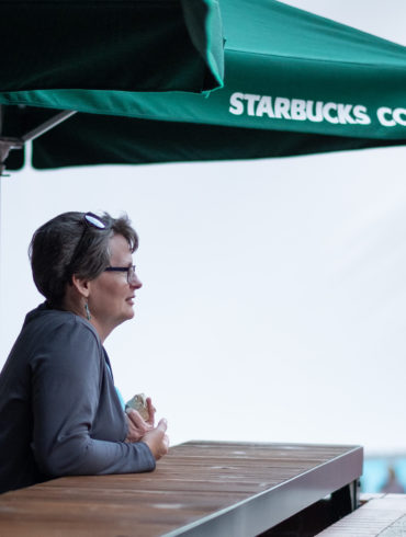 Woman sitting under Starbucks Umbrella