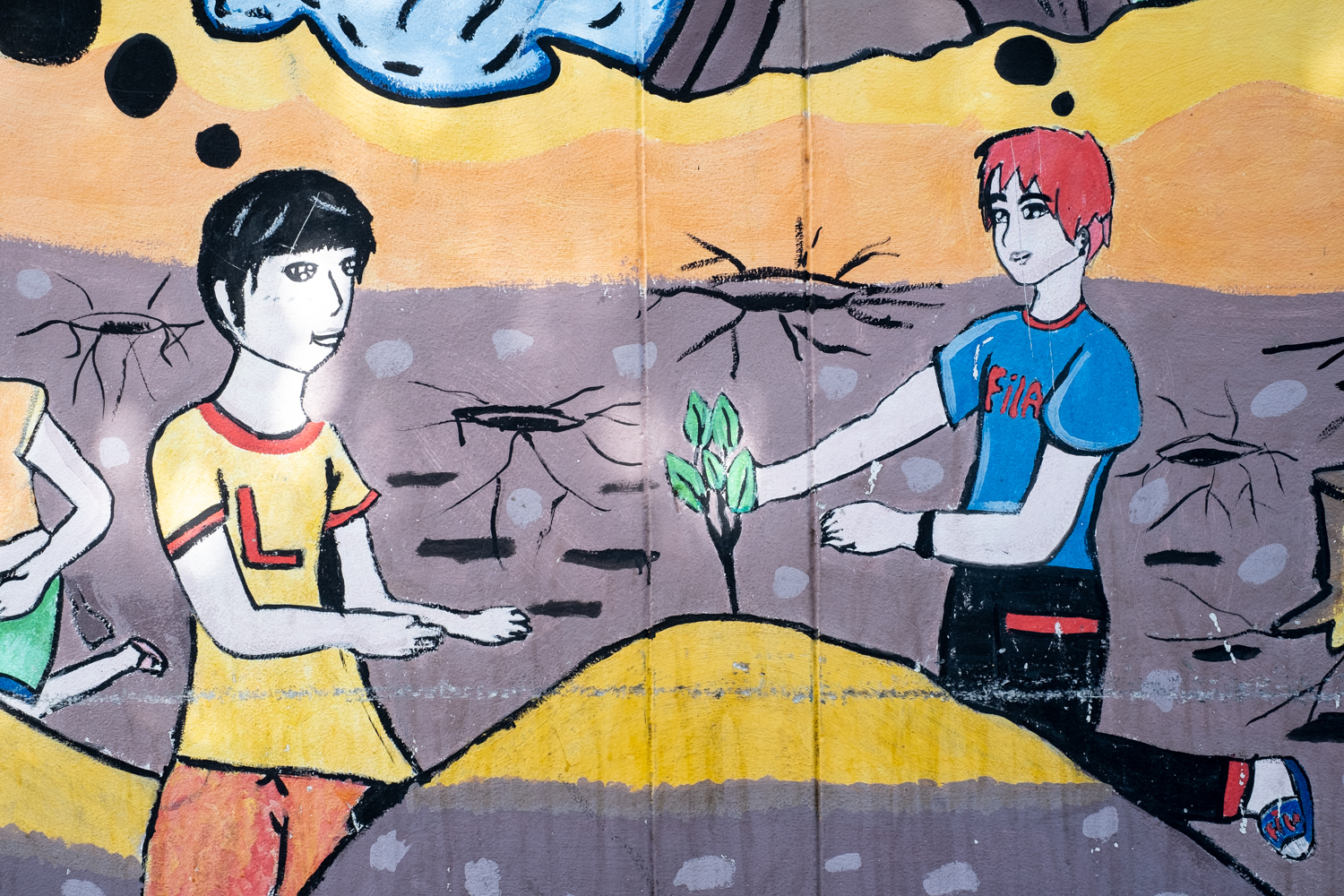 graffiti with two figures looking at a small plant with green leaves among a background of dead landscape