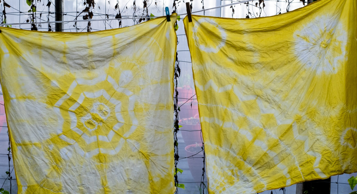 two squares of fabric with yellow tie dye designs