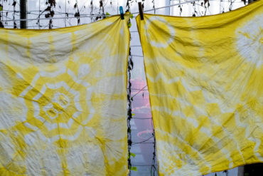 two squares of fabric with yellow tie dye designs