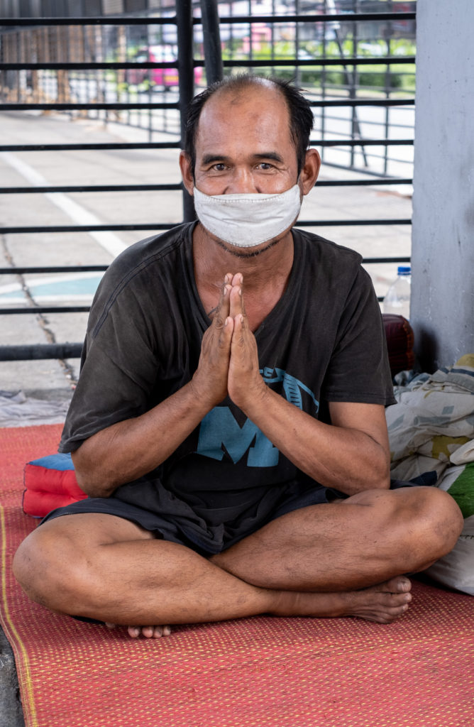 street person with hands in praying position