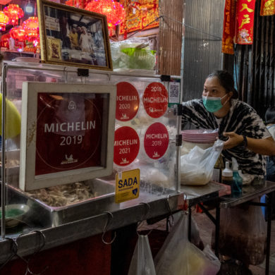 streetside restaurant with three women has Michelin Star signs