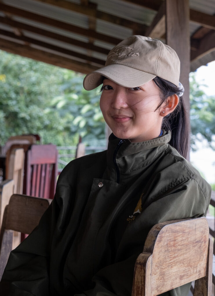 girl sitting in chair and wearing hat